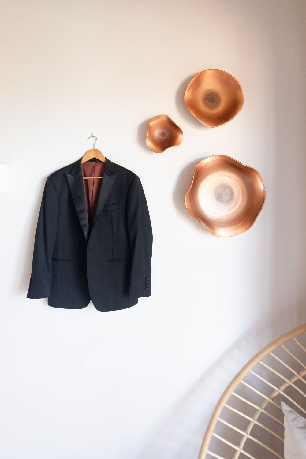 Classic navy blue suit jacket hanging on display against a white wall.