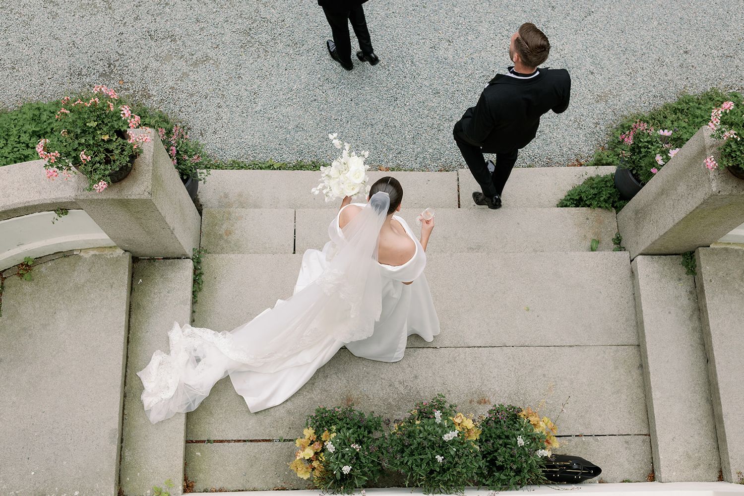 Wedding guests raise their glasses in a celebratory toast during an outdoor reception.