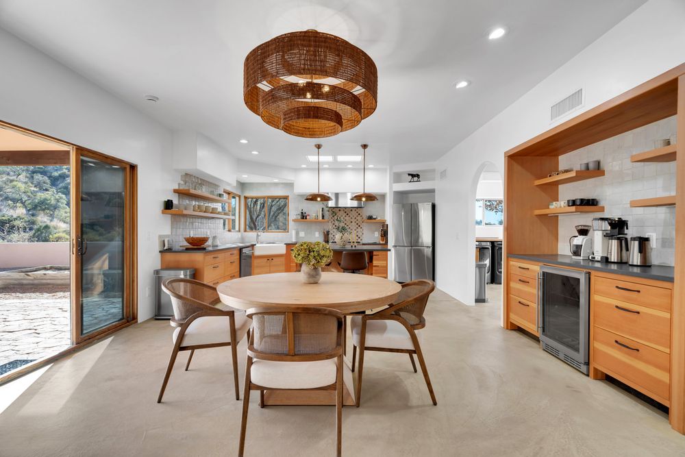 Modern open-concept living space with wood accents, white walls, and contemporary furnishings showcases seamless indoor flow.