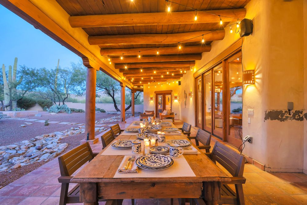 Warm-lit covered patio area with wooden beams and outdoor seating for entertaining.