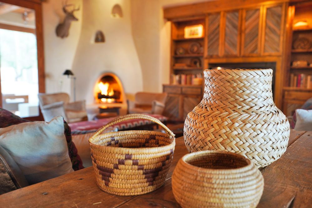 Rustic handwoven Native American baskets displayed on wooden shelves in warm lighting create a cozy southwestern ambiance.