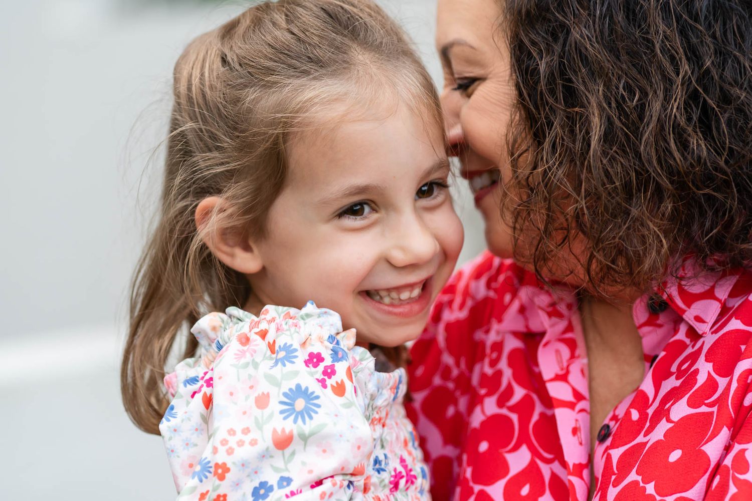 Grandma whispering a secret to granddaughter on a summer evening.