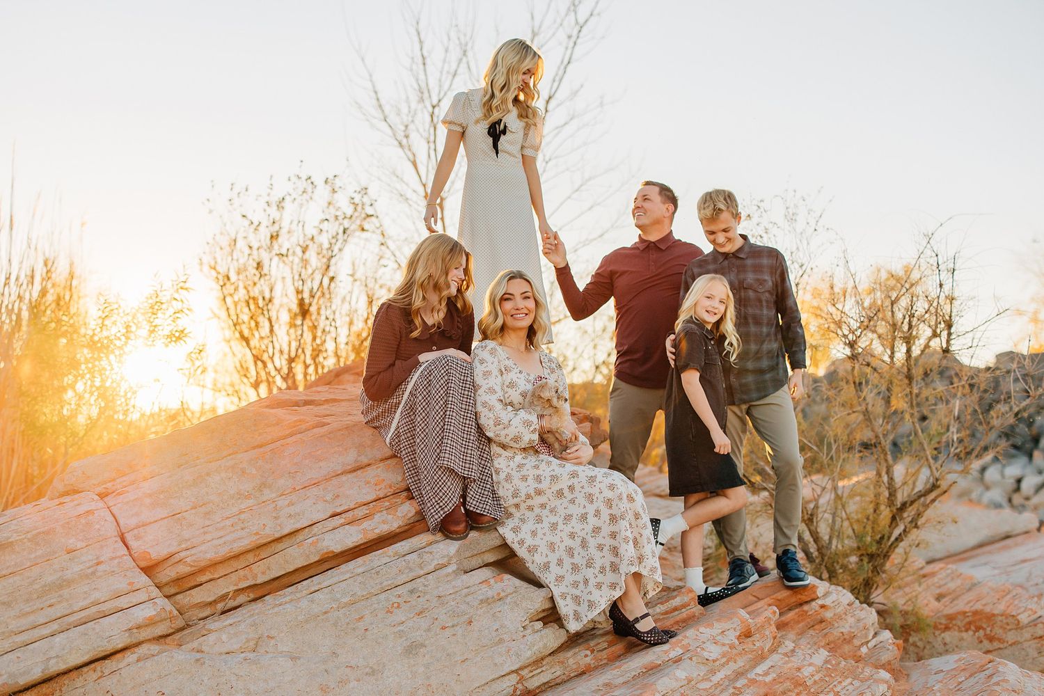 Sunset family photography session with golden light streaming through autumn trees.