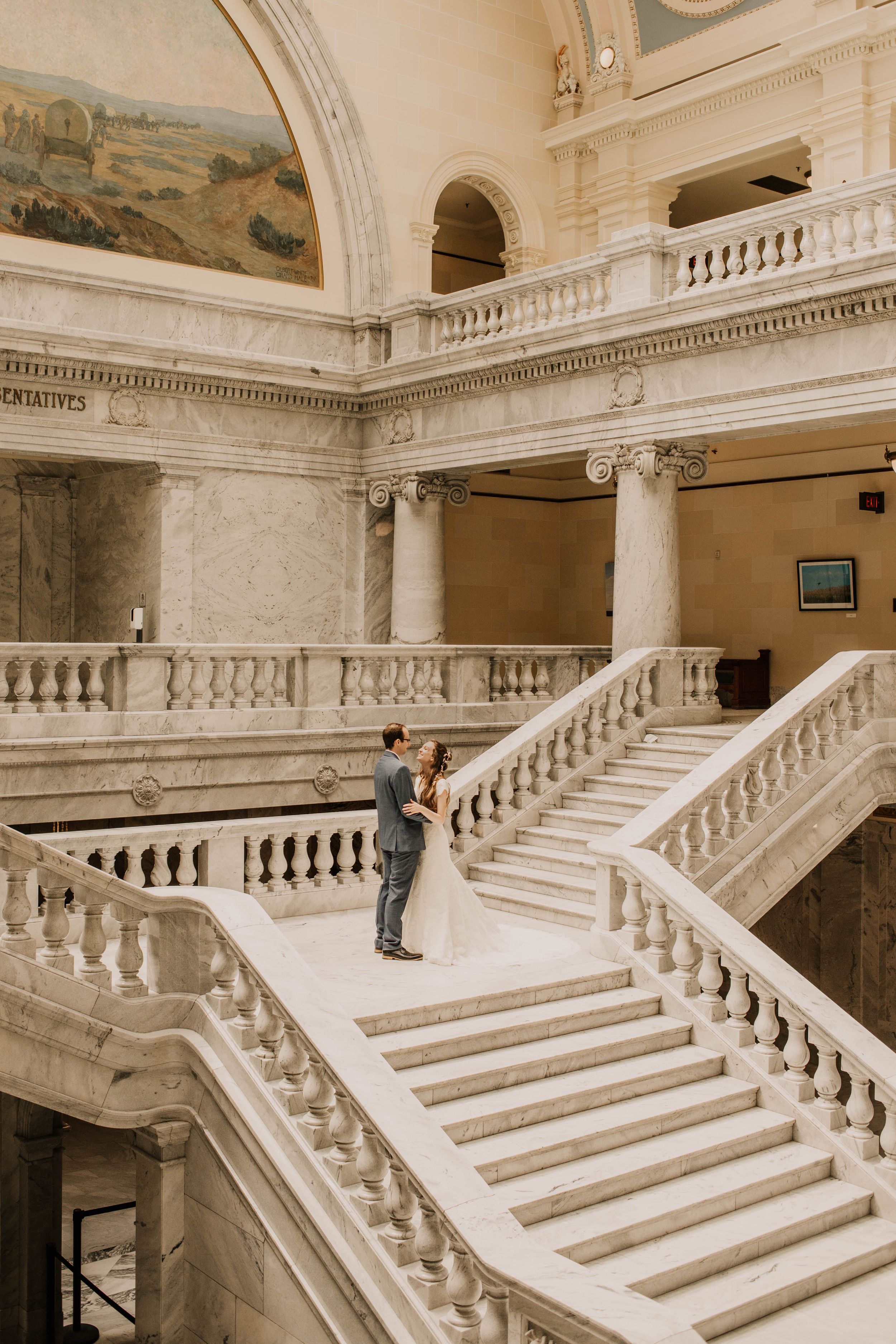 Elegant white marble staircase with ornate balustrades and classical architectural details in a grand historic building.