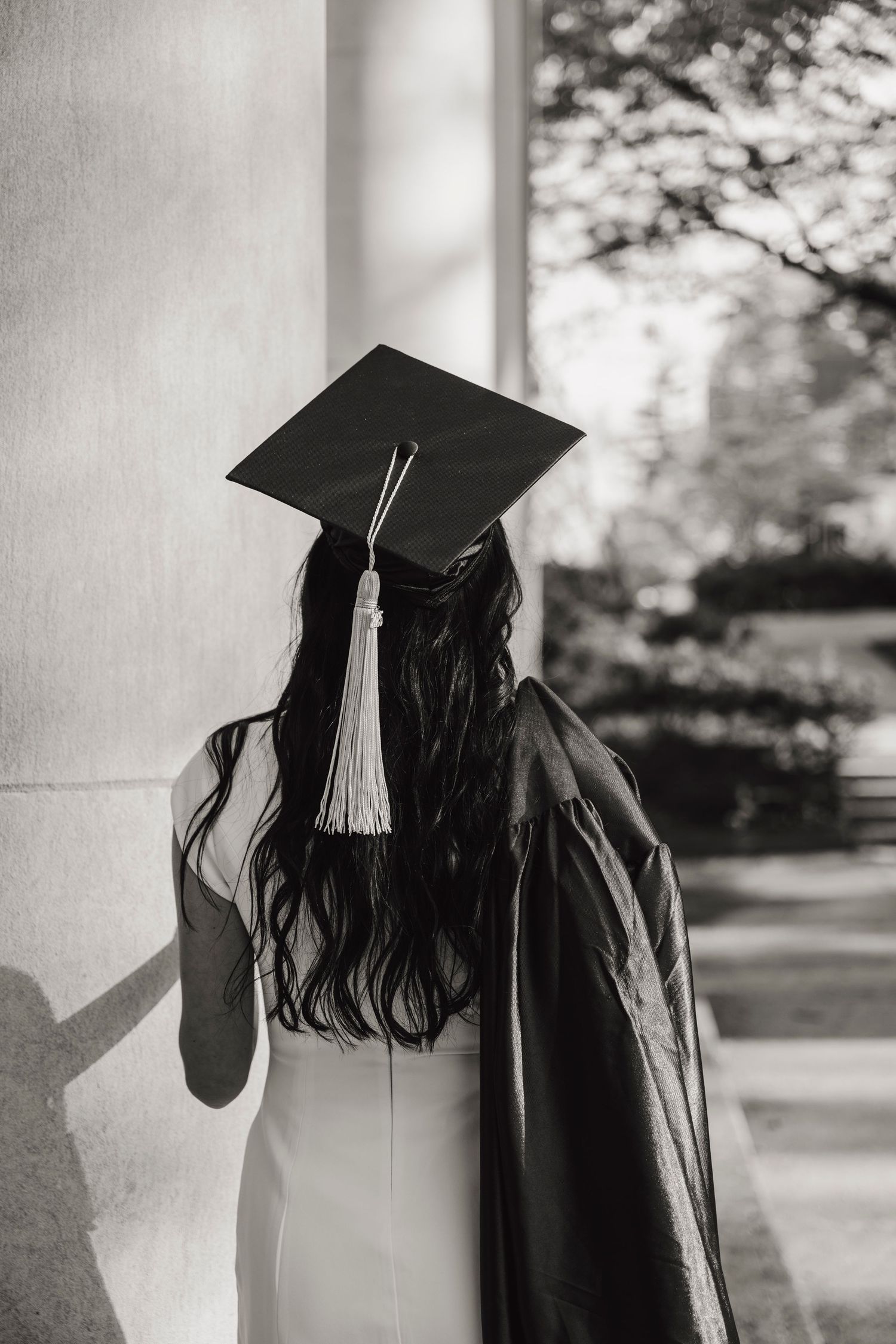 A black and white graduation photo sequence showing a person in a cap and gown looking down and to the side.