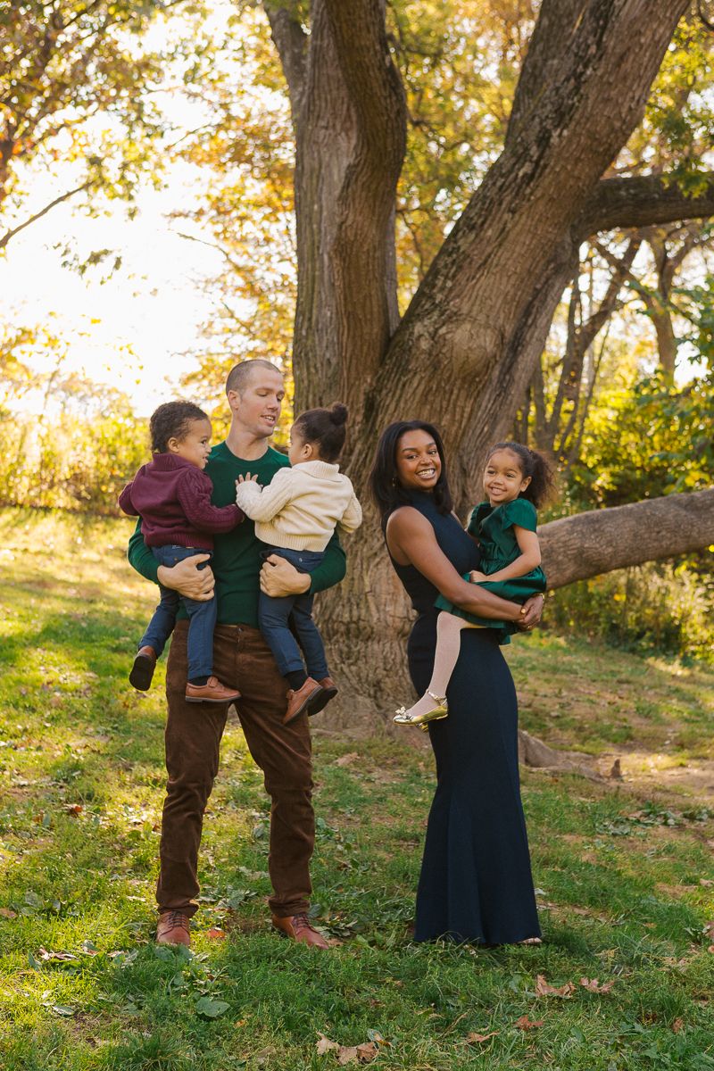 Family walking down tree-lined path in Prospect Park Brooklyn, editorial photography style