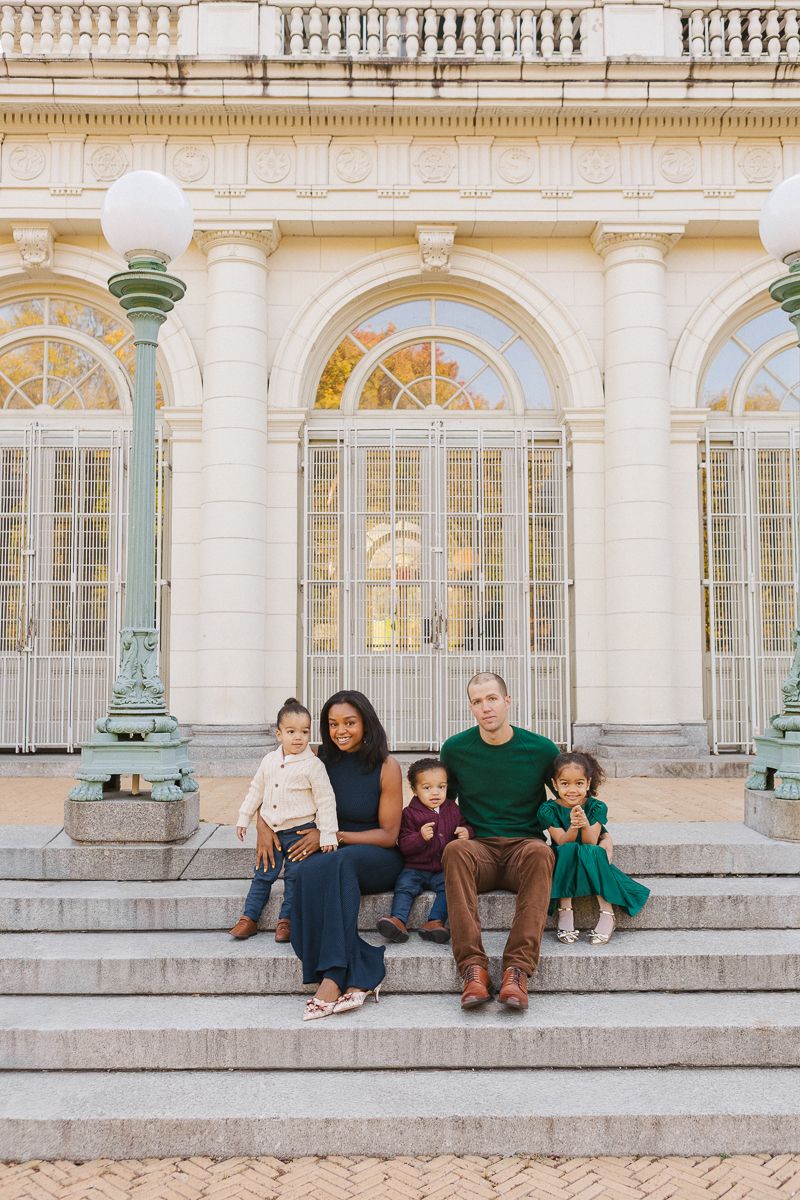 Young family smiling on the Boathouse steps in Prospect Park, Brooklyn