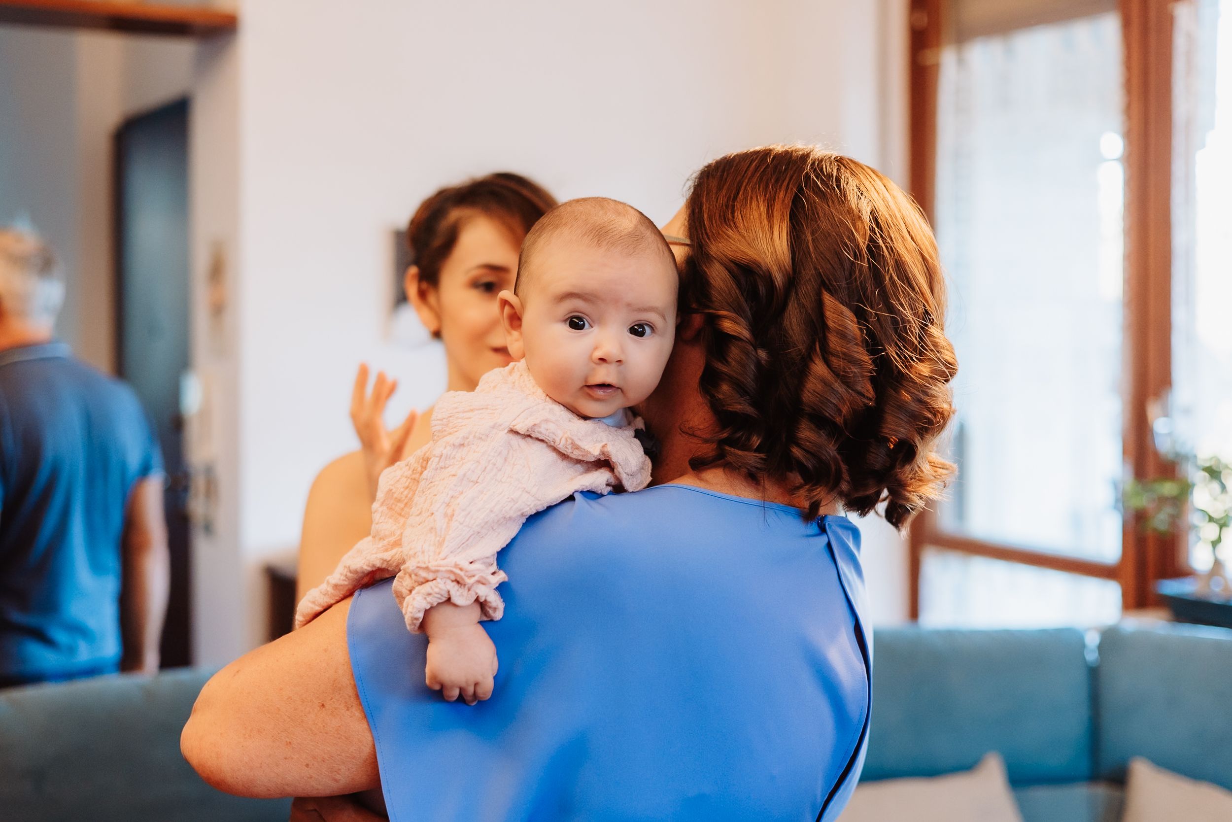 A sequence of photos showing a parent in blue embracing a small child in a tender moment.