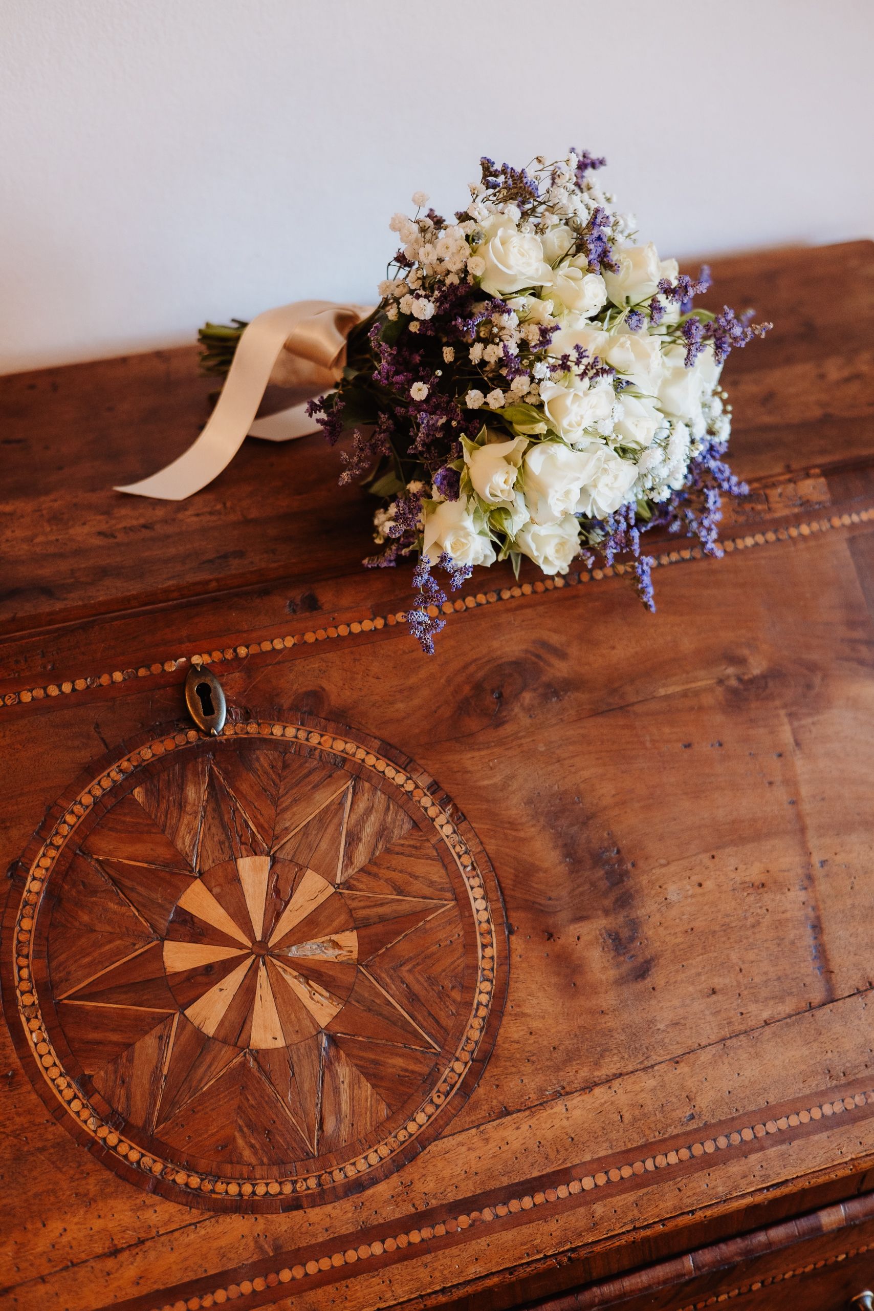 A rustic wooden table with inlaid compass design and floral bouquet displayed across multiple angles.