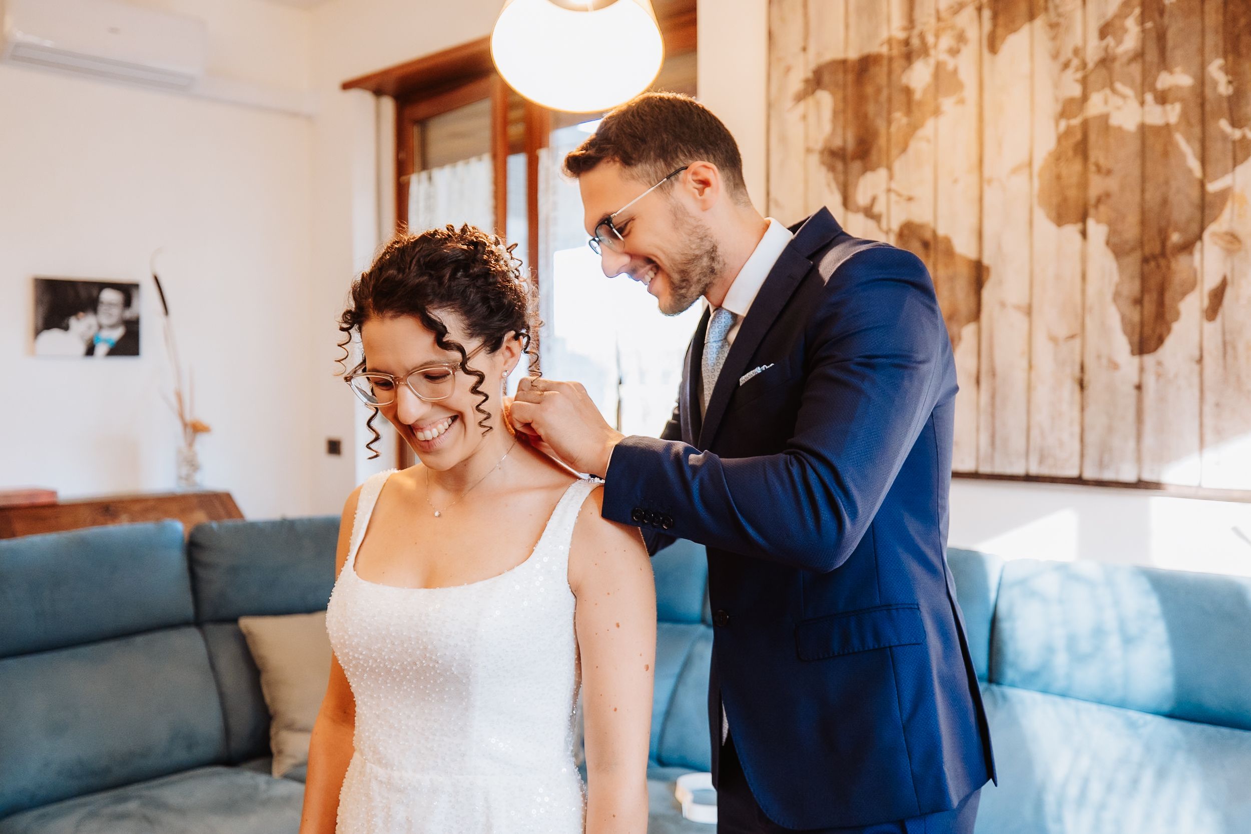 A wedding couple shares an intimate moment in front of a rustic wooden wall with soft lighting.