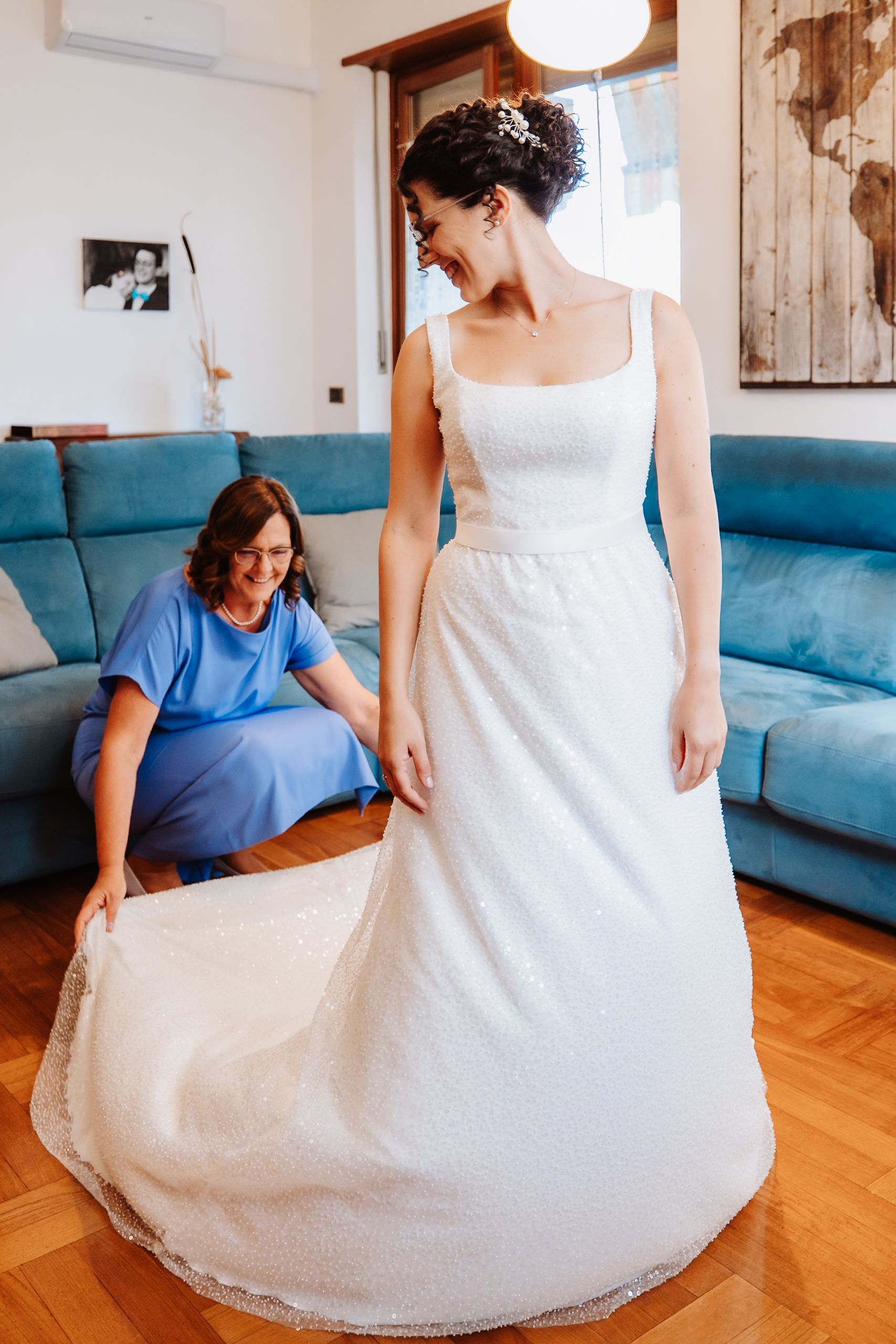 A series of photos showing a wedding dress being fitted and adjusted on a wooden floor next to a blue couch.