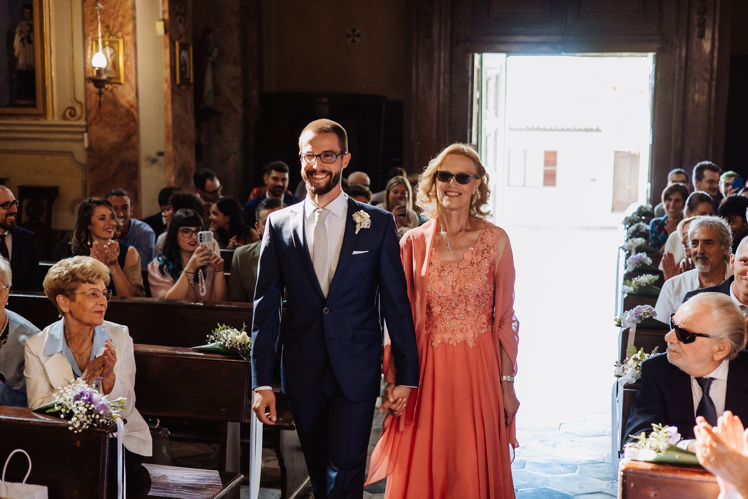 Wedding guests gather in an ornate church interior during an emotional ceremony.