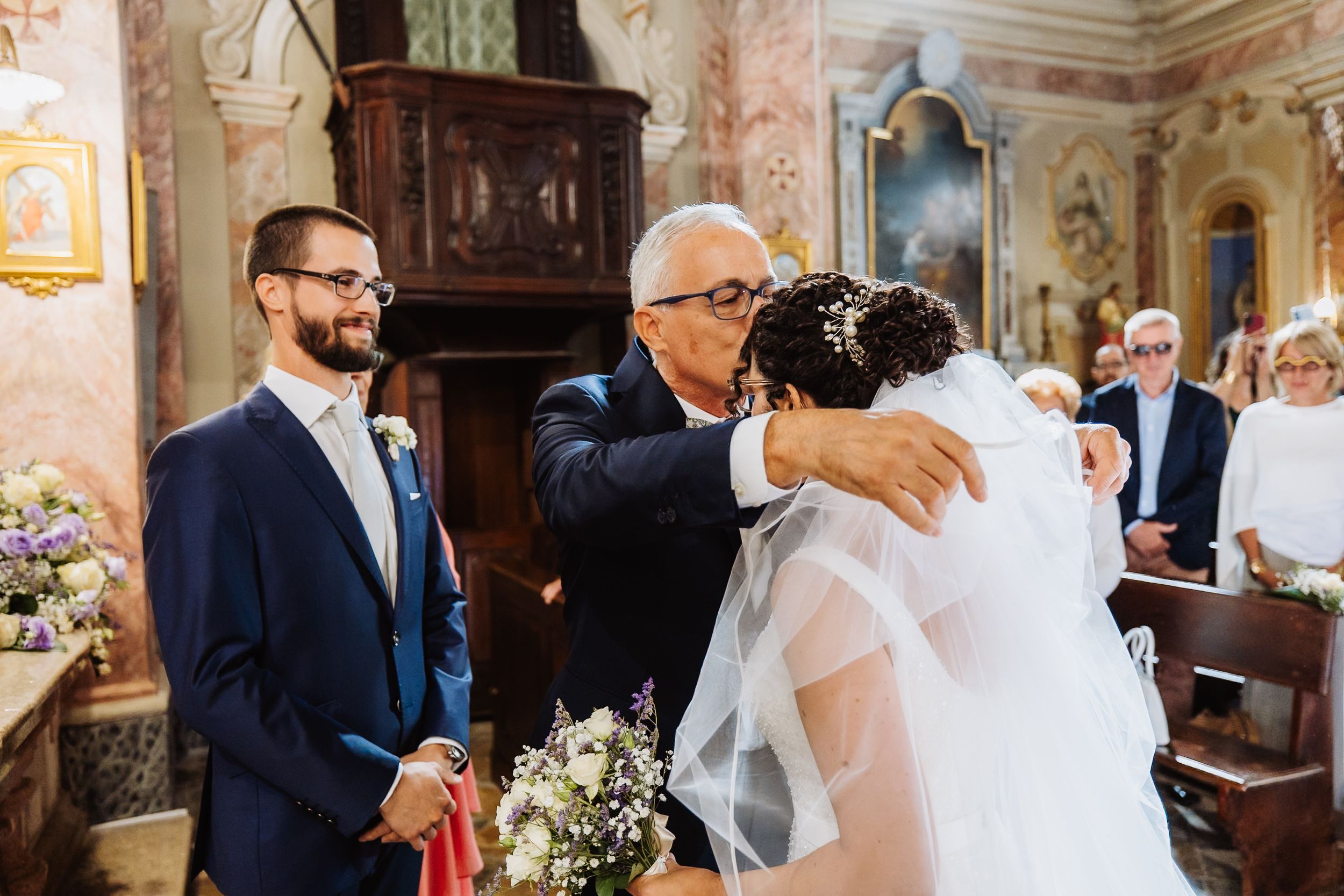 Interior of an ornate church during a wedding ceremony with elegant decor and natural lighting.