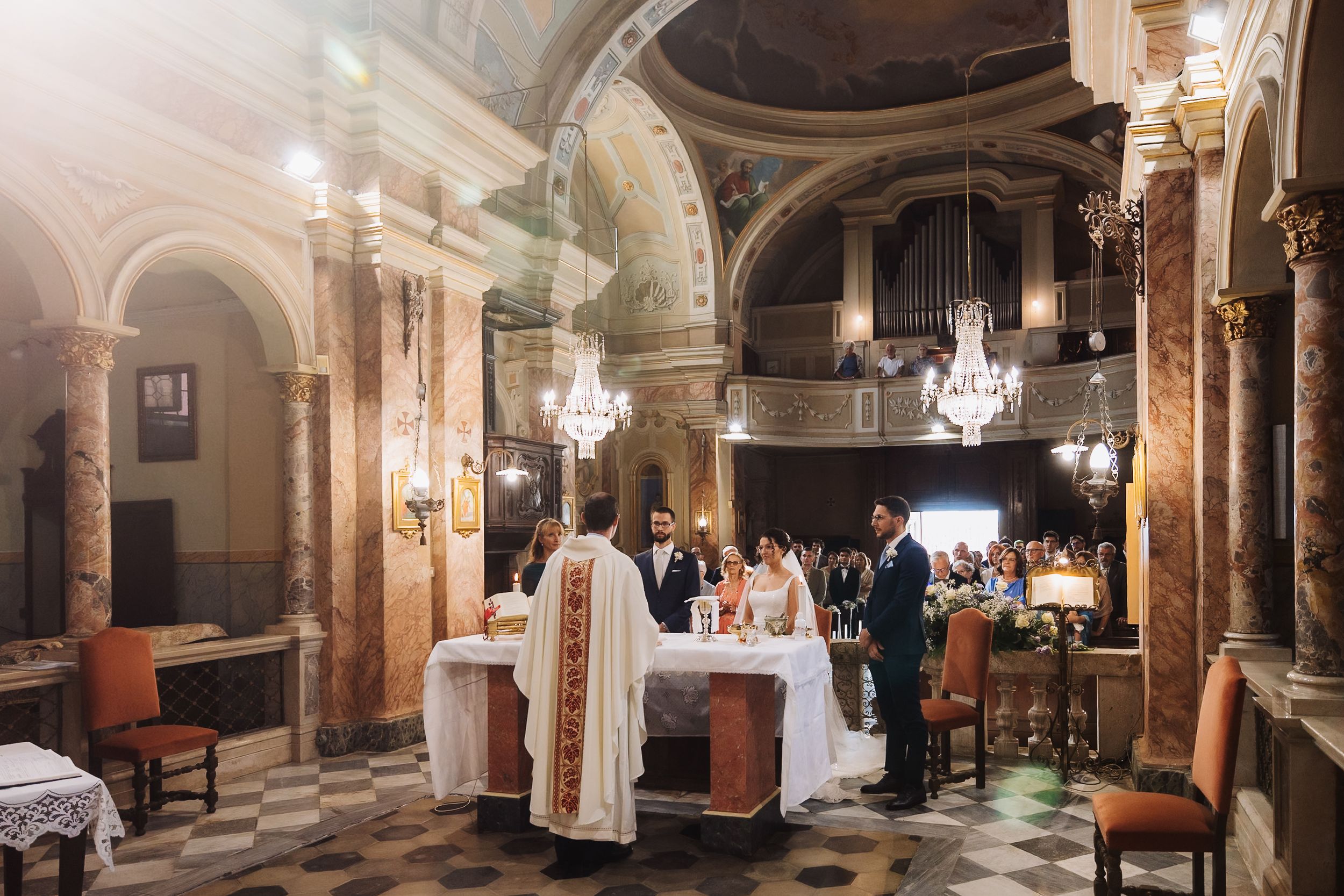 A panoramic view of an elegant ballroom interior with ornate columns, chandeliers and arched architecture.