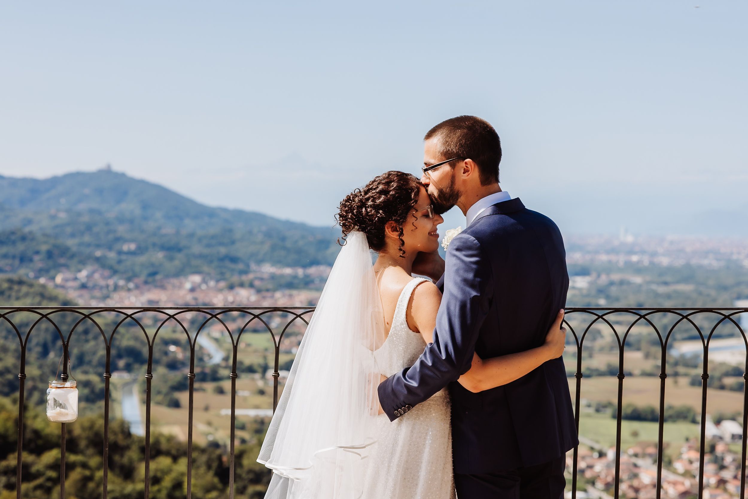 Couple shares romantic moments overlooking a scenic mountain landscape during their wedding photoshoot.