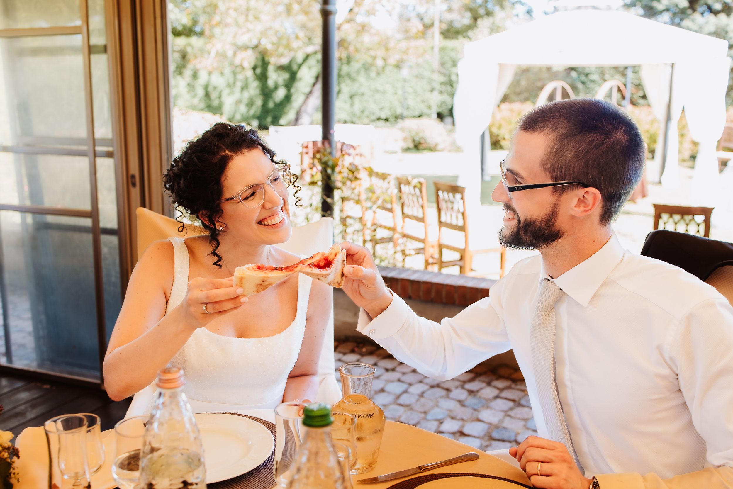 A group of friends enjoying wine and conversation on an outdoor patio during a sunny afternoon.
