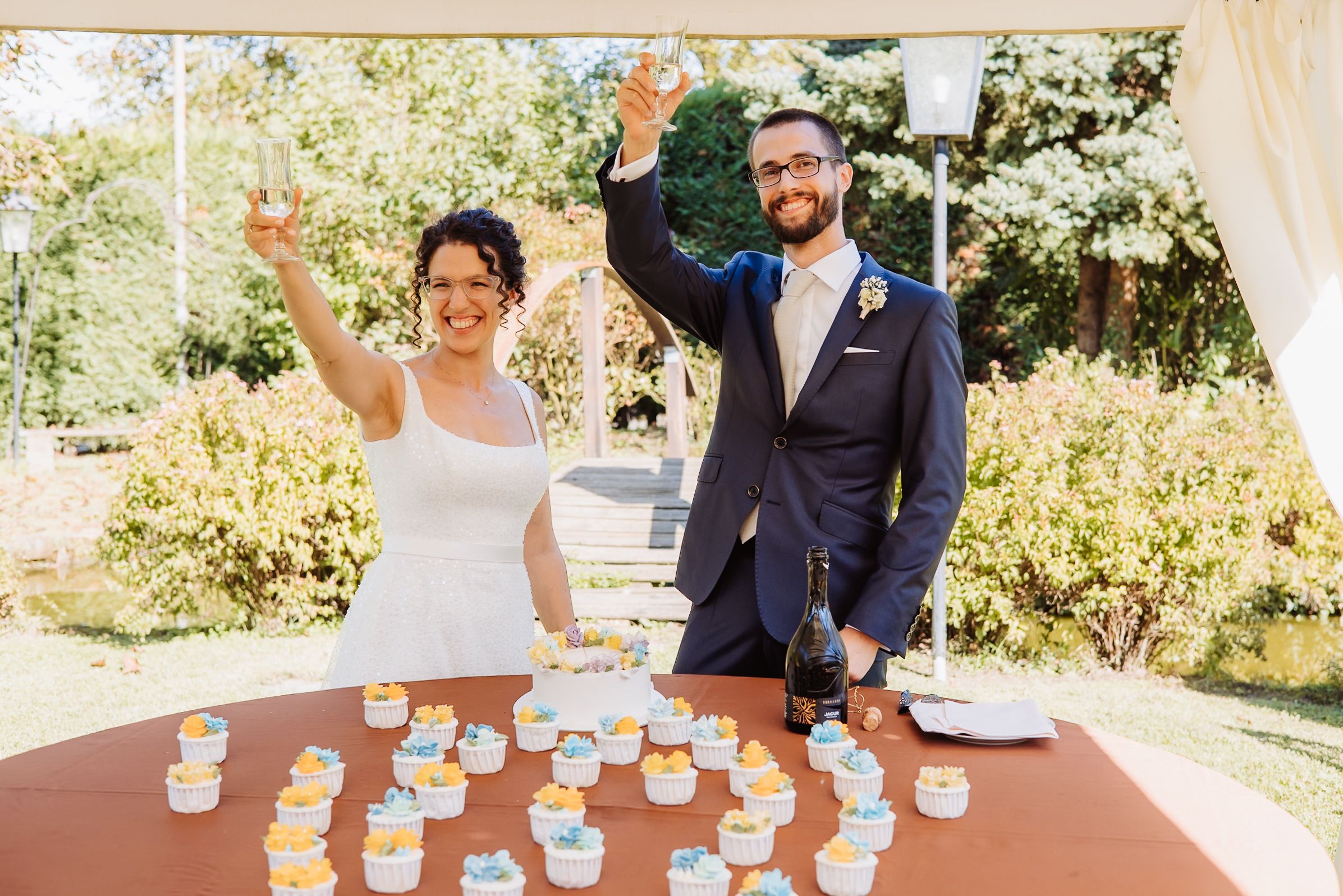 Guests play a fun cup flipping game at an outdoor party table during a sunny afternoon celebration.