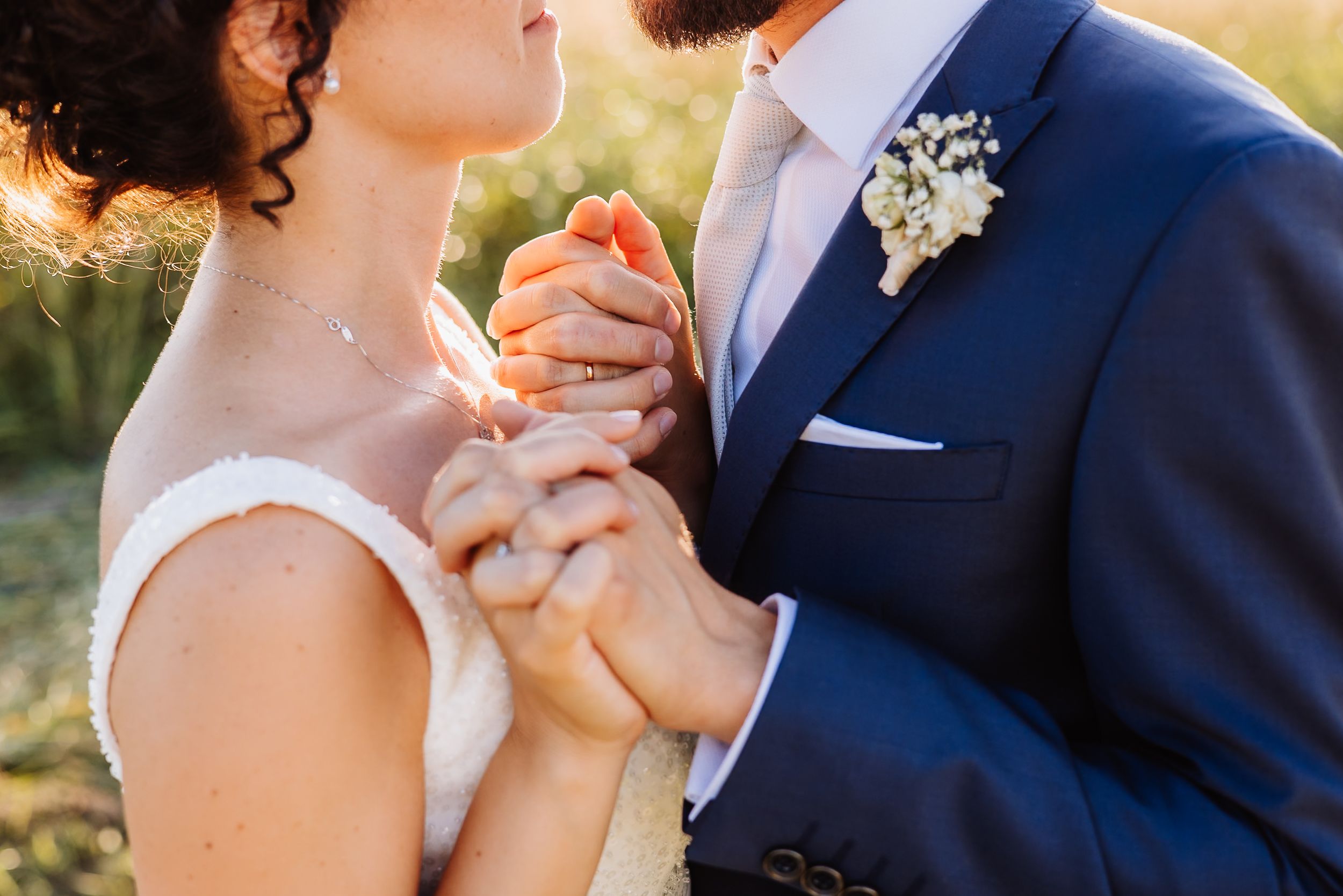 A couple shares an intimate moment during their outdoor wedding ceremony at golden hour.