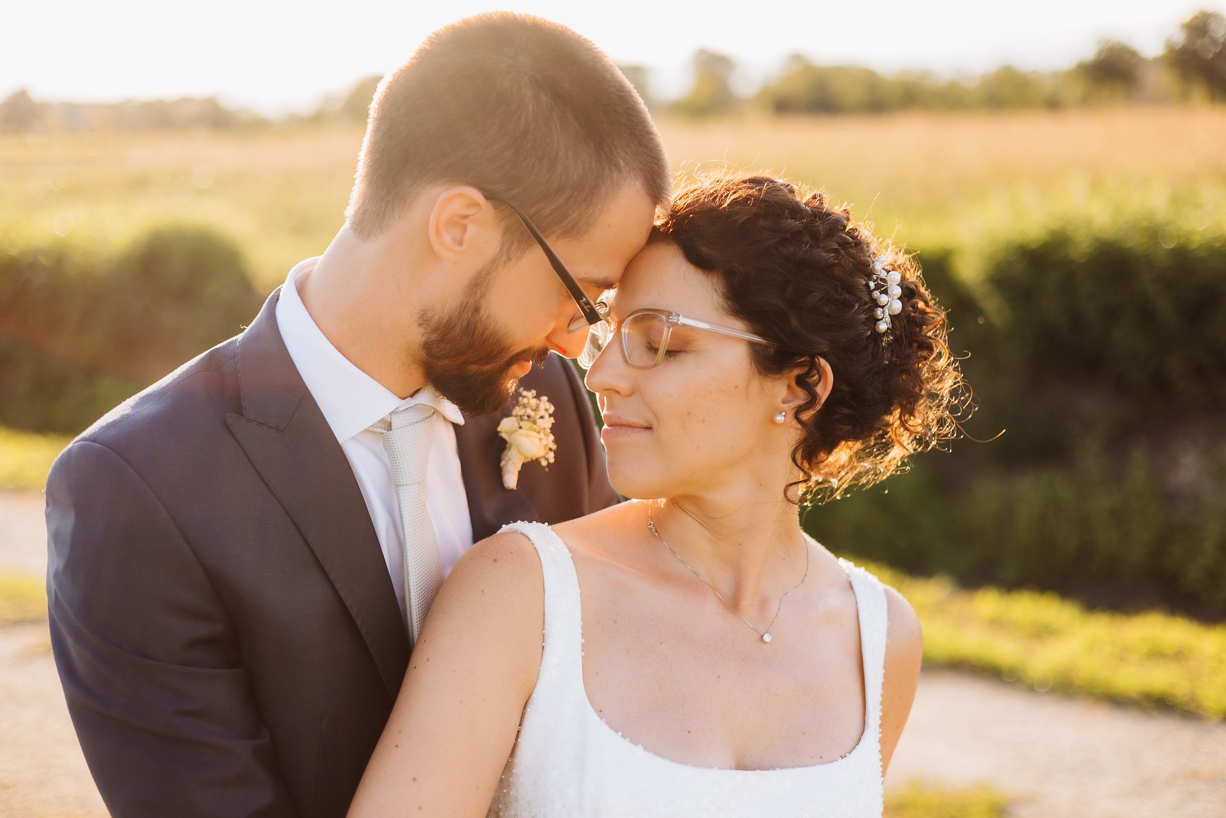 A romantic couple shares tender moments during their outdoor wedding photoshoot at golden hour.