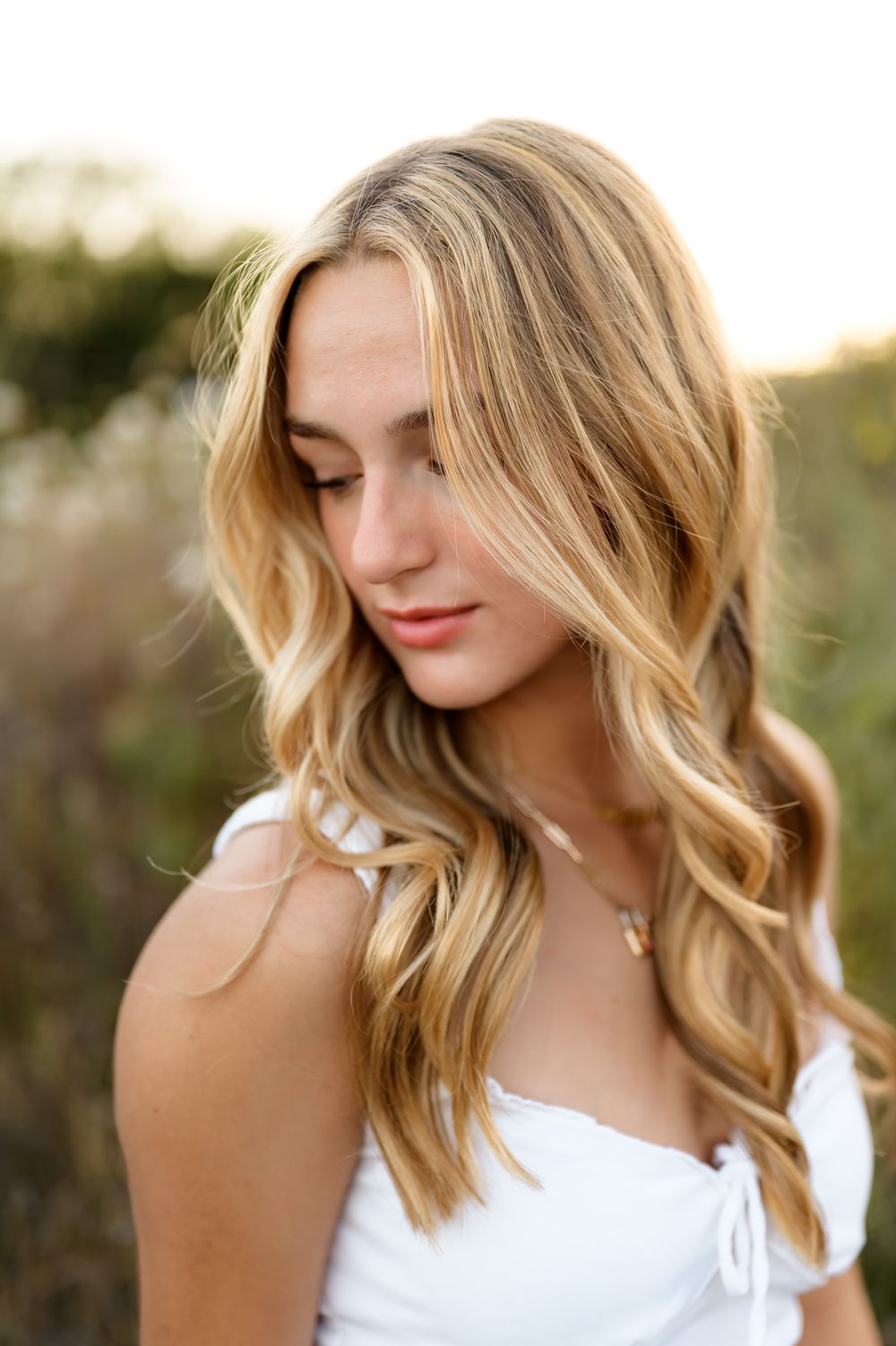 High school senior posing in white dress & cowboy boots at Ojai Valley Preserve during outdoor senior portrait session Ventura photographer