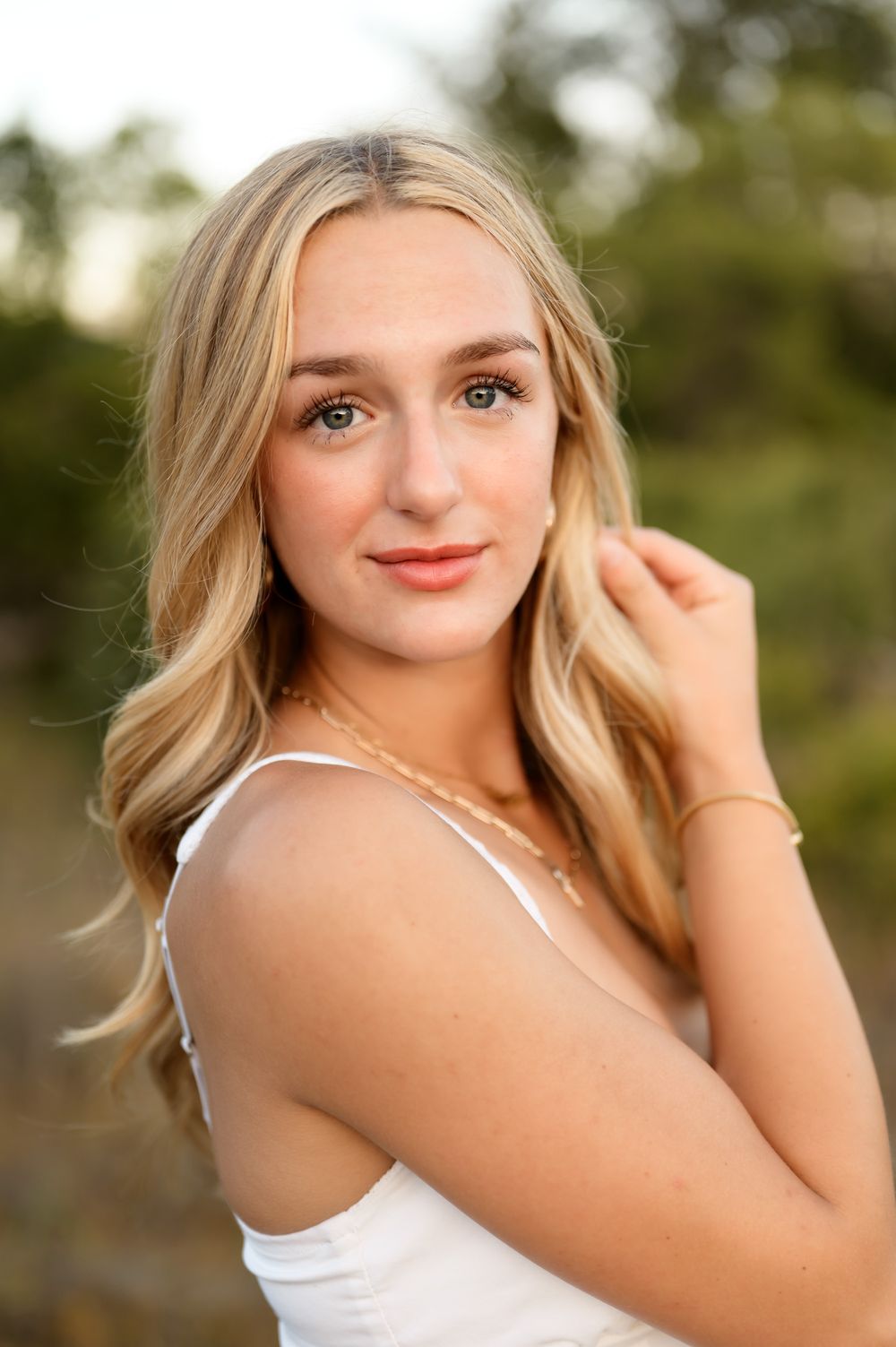 High school senior posing in white dress & cowboy boots at Ojai Valley Preserve during outdoor senior portrait session Ventura photographer
