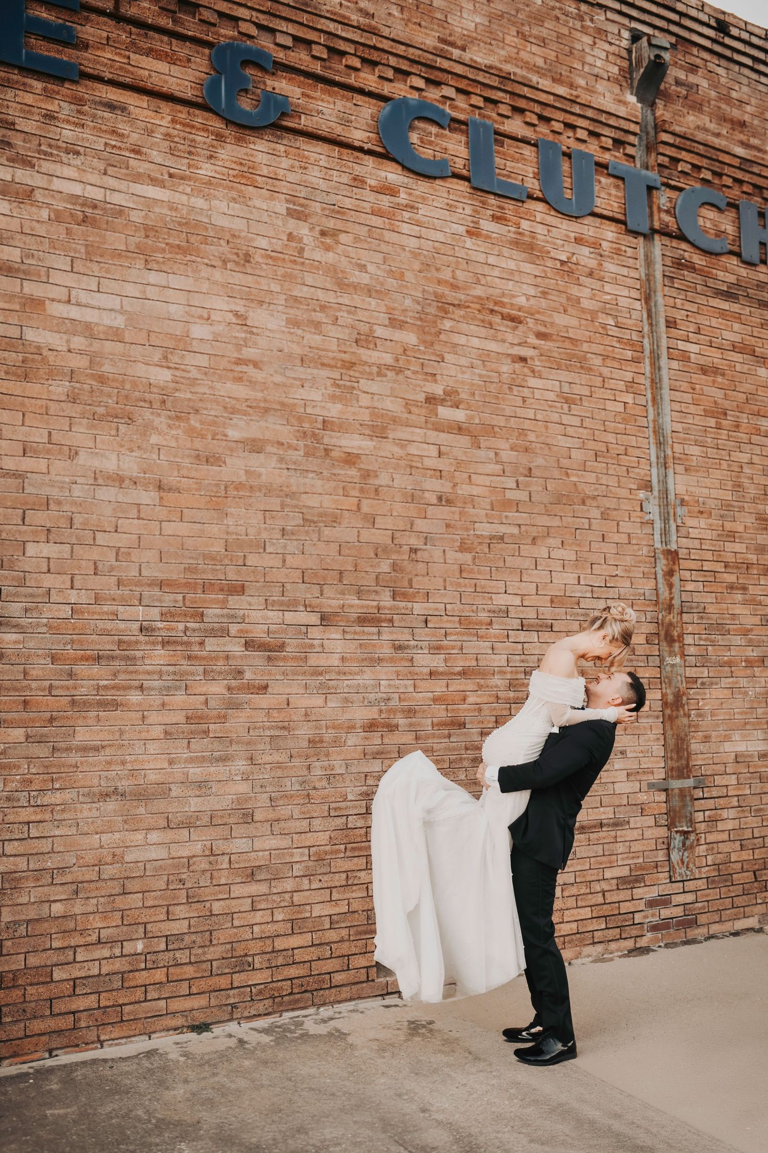Bride and groom running playfully through Deep Ellum as the sun sets, creating joyful and candid editorial wedding portraits