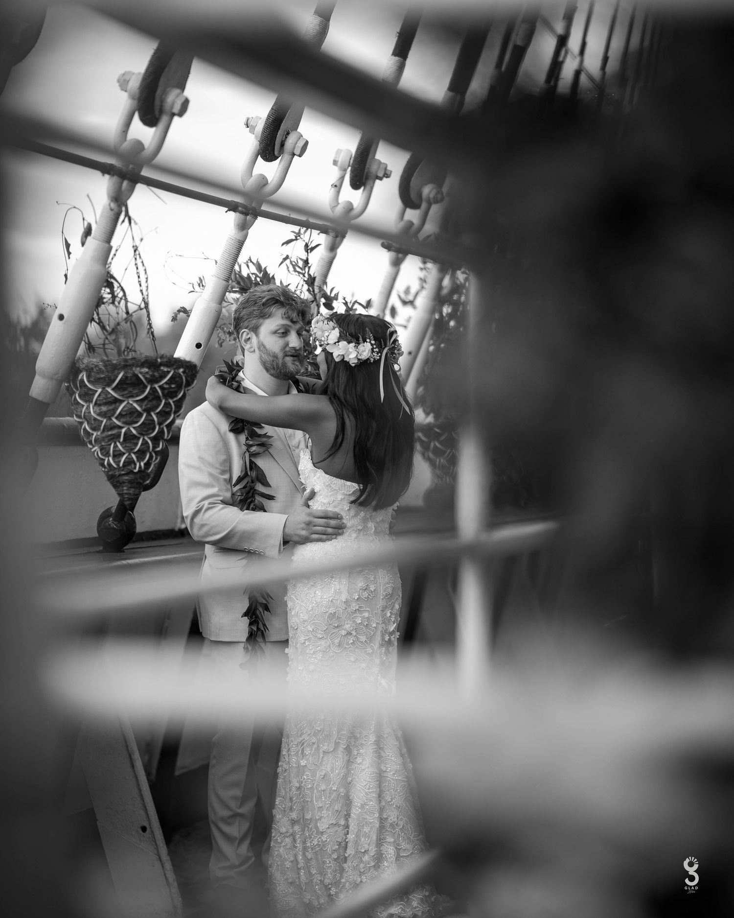 A romantic black and white wedding dance moment captured through blurred foreground elements creating a dreamy atmosphere.