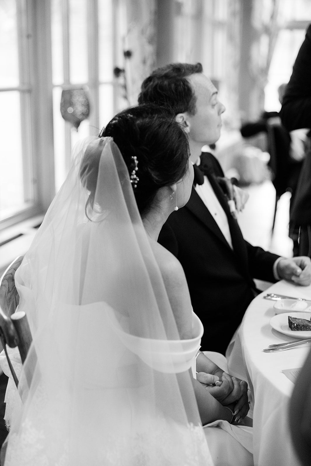 A series of black and white wedding photographs showing a bride in a veil from different angles during the ceremony.
