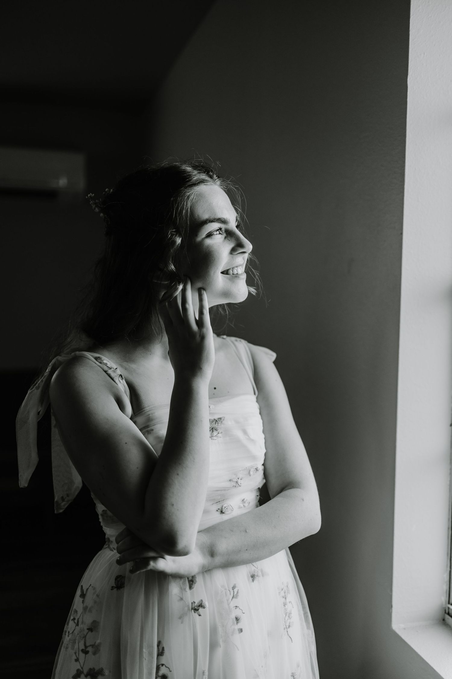 Artistic black and white portrait capturing intimate moments in natural window light.