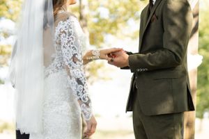 A couple exchanges rings during their outdoor wedding ceremony.