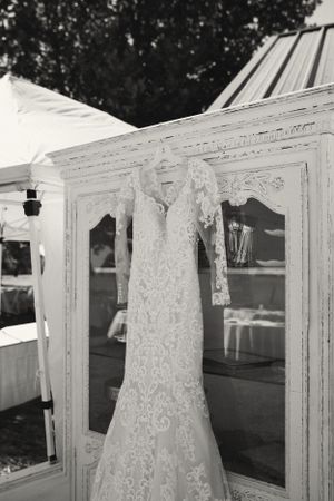 Wedding dress displayed on white vintage window frames in black and white photography.