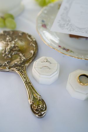 Ornate vintage-style hand mirrors with decorative metalwork displayed on white surface.