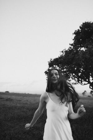 Black and white portrait of carefree movement in white dress outdoors.