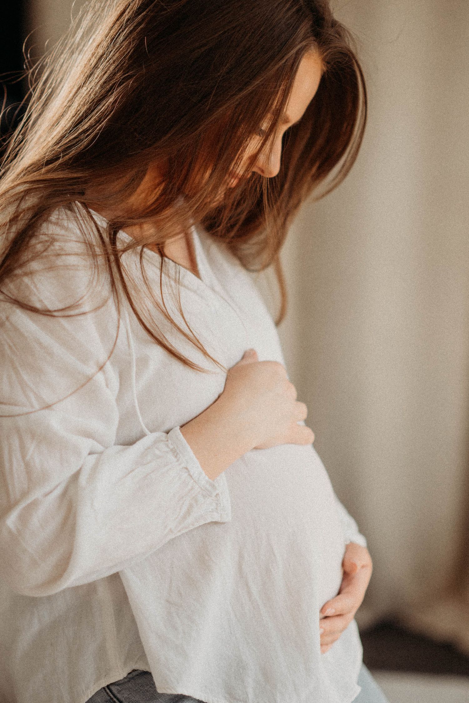 Series of soft, intimate maternity photos in white clothing.