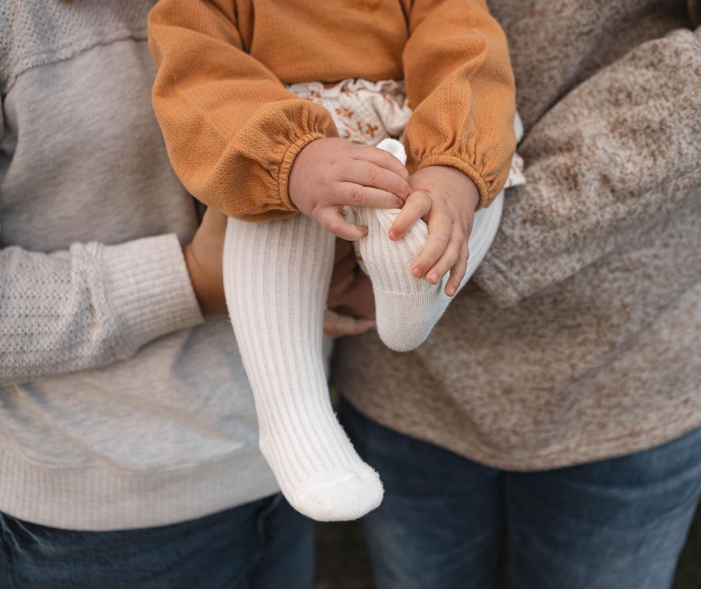 A series of photos showing hands putting on a white knit sock, demonstrating the step-by-step process of wearing socks.