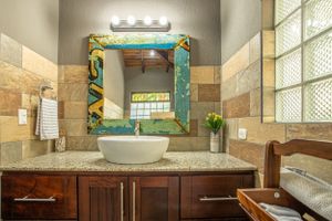 Luxury bathroom with wooden vanity, double sinks, and glass shower in a gated community in Atenas