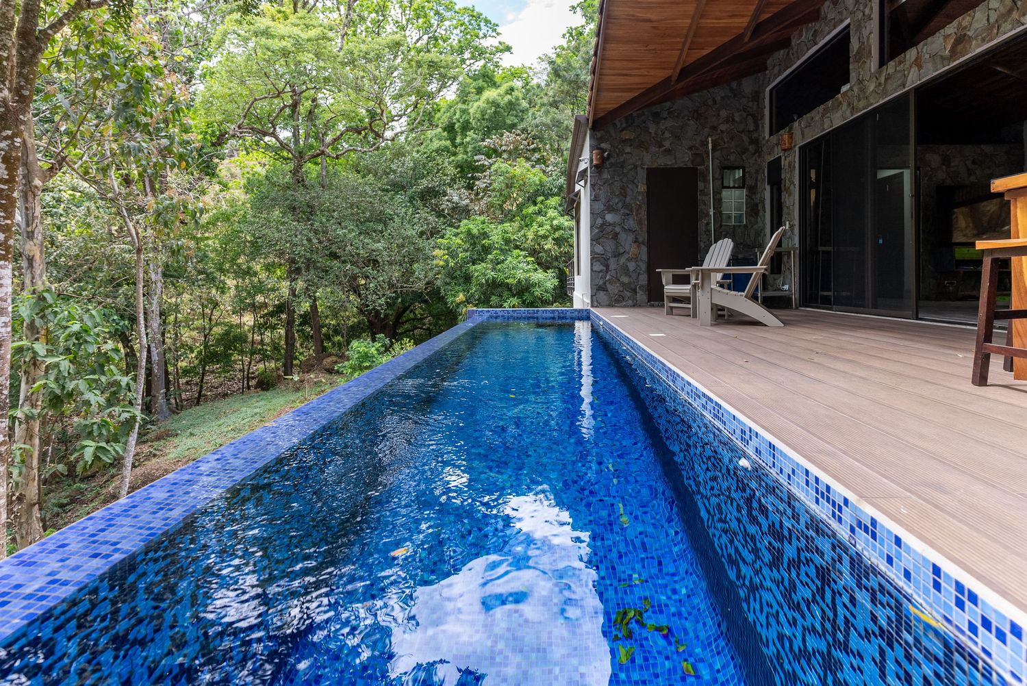 Sparkling pool surrounded by lush tropical vegetation in a gated community in Atenas, Costa Rica. Ideal for relaxing and enjoying the weathe