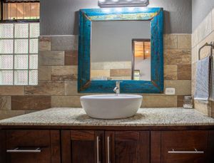 Luxury bathroom with wooden vanity, double sinks, and glass shower in a gated community in Atenas