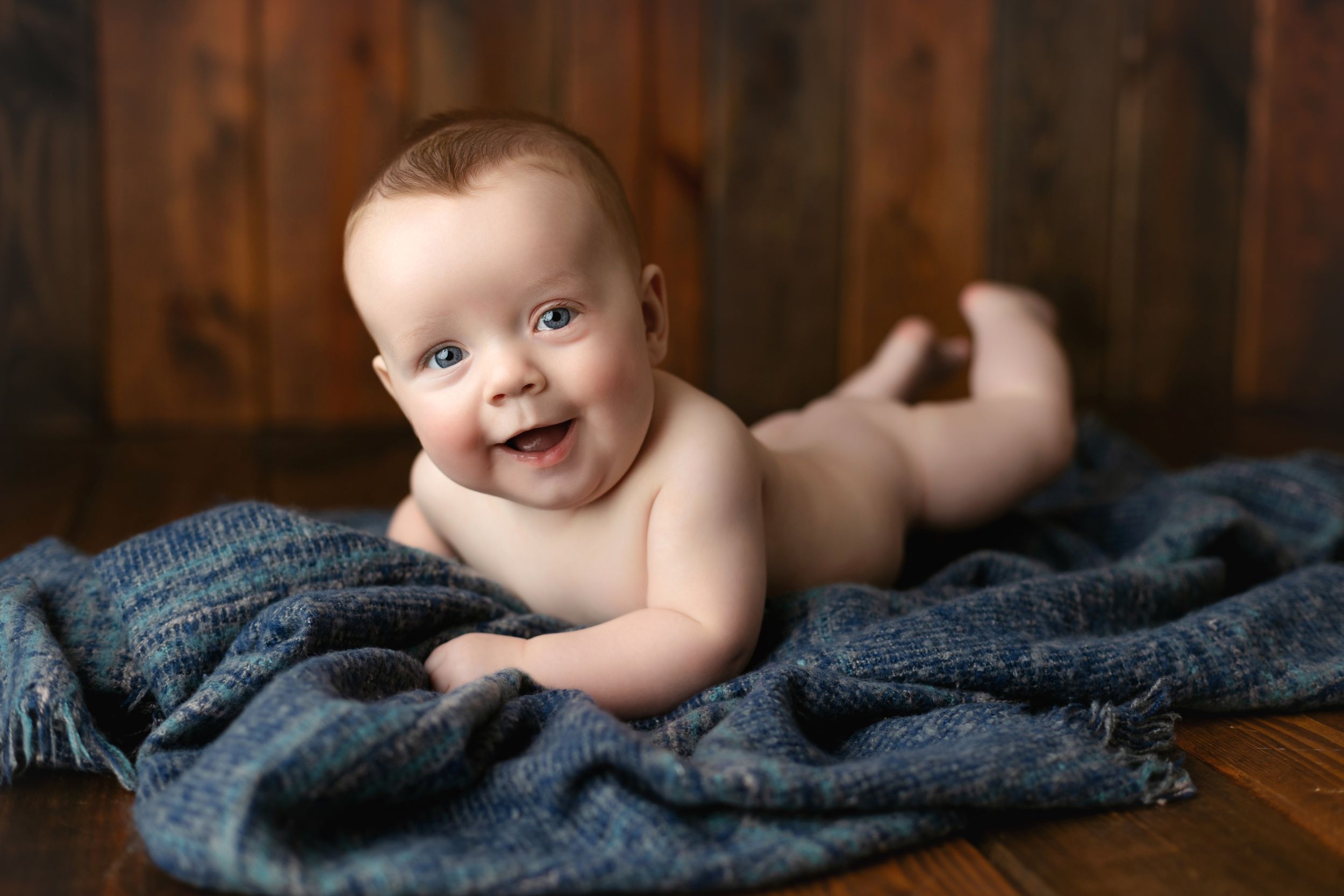 A 6-month-old with a green outfit lying on his belly. Greenville SC newborn photographer, Easley SC newborn photographer