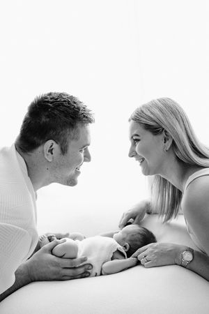 Black and white romantic photo sequence showing tender moments between a couple lying down together.