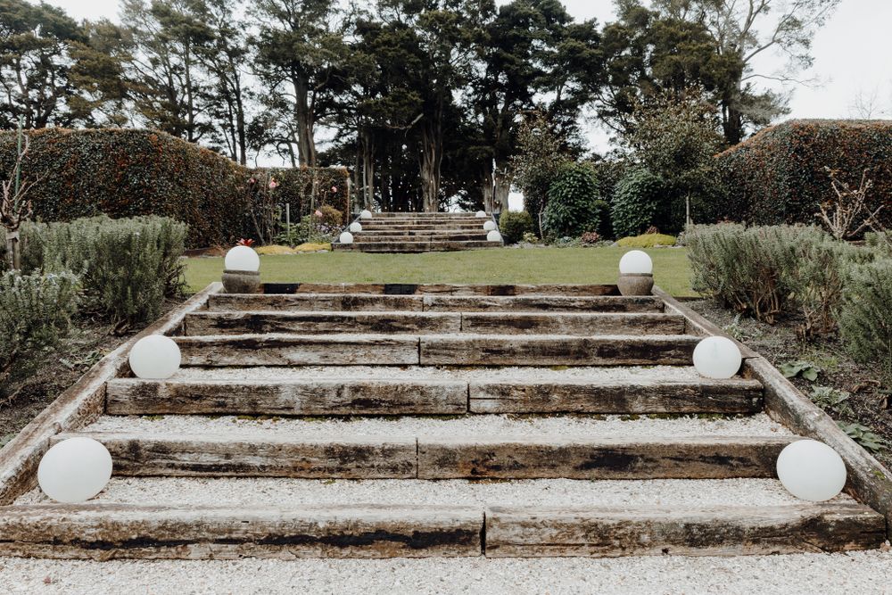 Stone steps leading up to a garden venue decorated with white spherical lanterns.