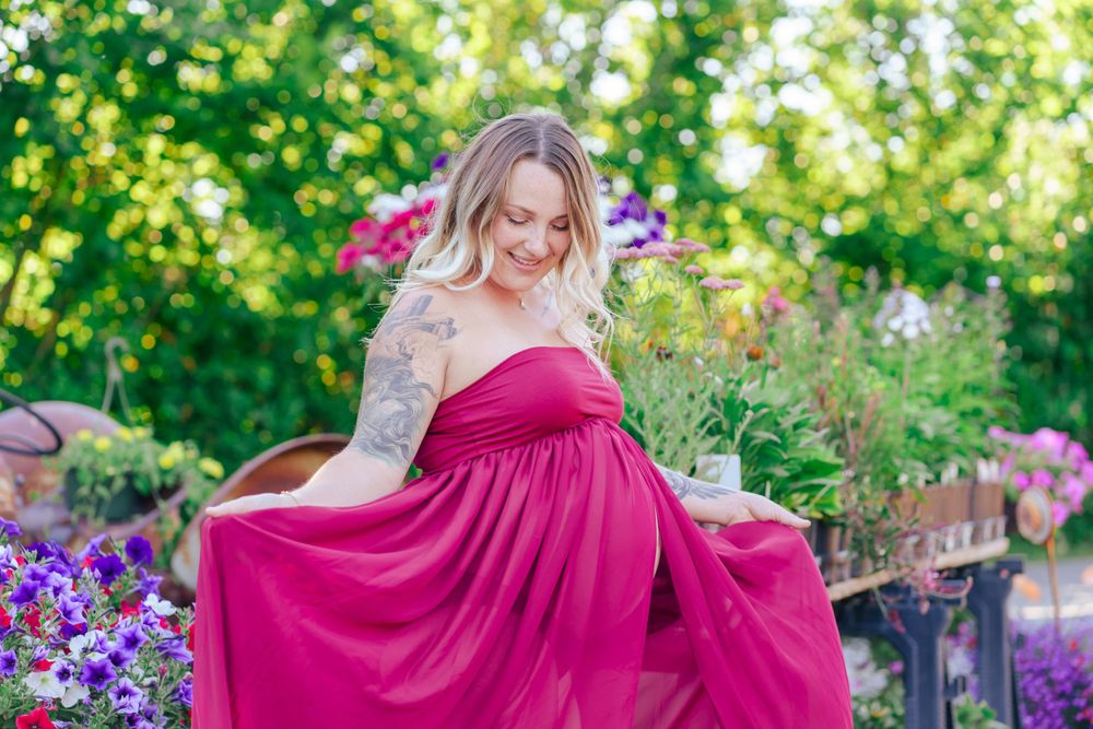 maternity portrait of mom with a pink flowy dress by flowers