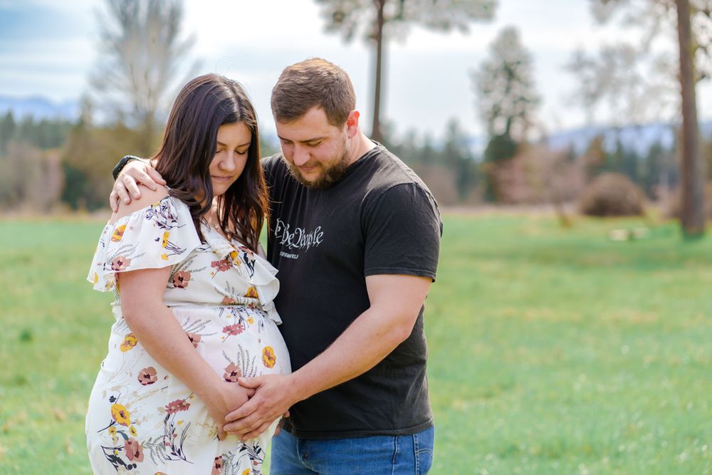 maternity portrait of mom and dad in a field