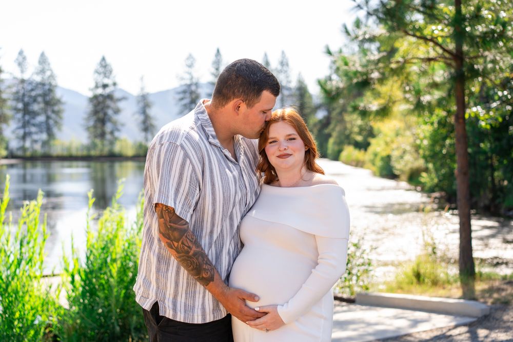 Maternity portrait of mom and dad by a pond