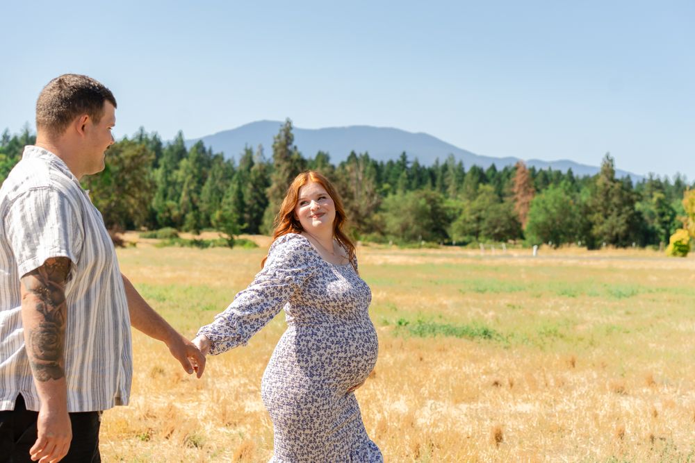Maternity session with mom looking back at dad while holding baby bump