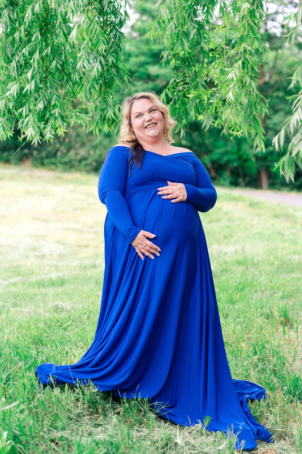 maternity portrait of mom with a blue dress by a willow tree
