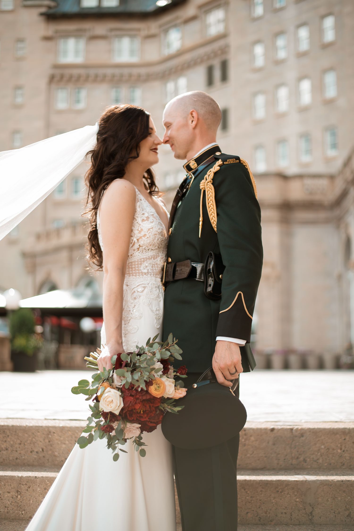 A romantic wedding portrait featuring a couple in formal attire against a historic building backdrop.