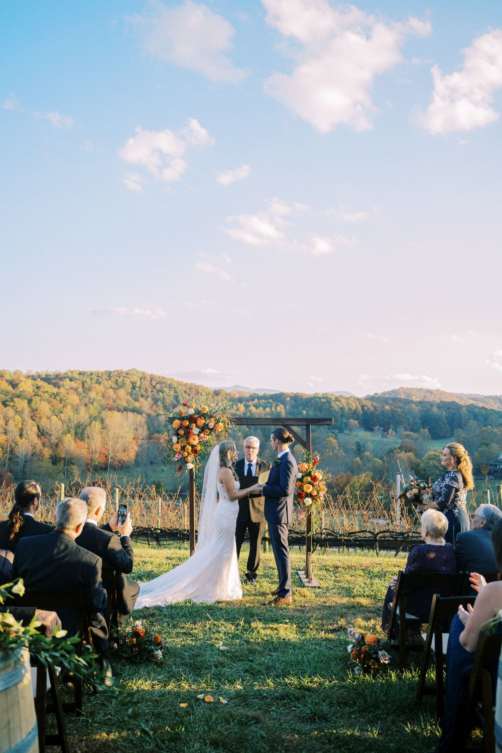 Outdoor wedding ceremony setup with mountain views and fall foliage in the background.