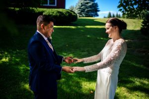 Bride and groom hold hands outdoors during an intimate first look on their wedding day.