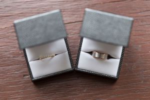 Four identical silver or white metallic folded card holders arranged in a row on dark wood surface.